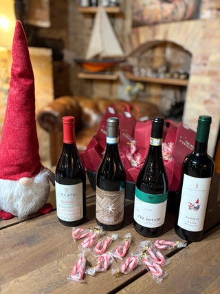 Piemonte Adventskalender 2026 – L.A. Cetto Nebbiolo, La Ganghija Langhe Nebbiolo, Pico Maccario Tre Roveri Nizza og Josetta Saffirio Barolo Riserva med røde gaveposer og sukkerstokke