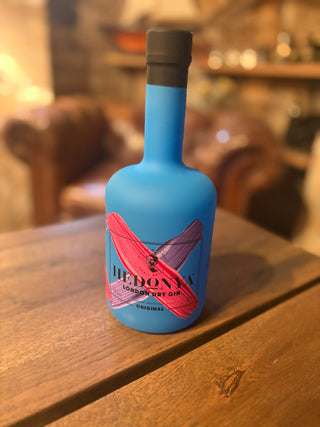 Hedonya Original London Dry Gin blå flaske på træbord i vinkælder